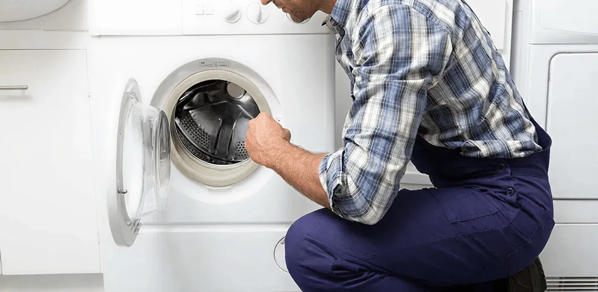 Handyman inspecting a dryer drum and internal parts for repair in Portland, OR