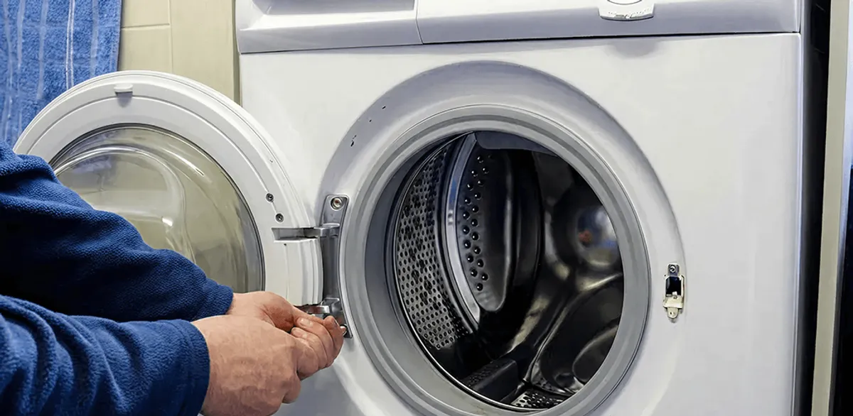 Washing machine repair handyman checking a front-load washer door and latch in Portland, OR