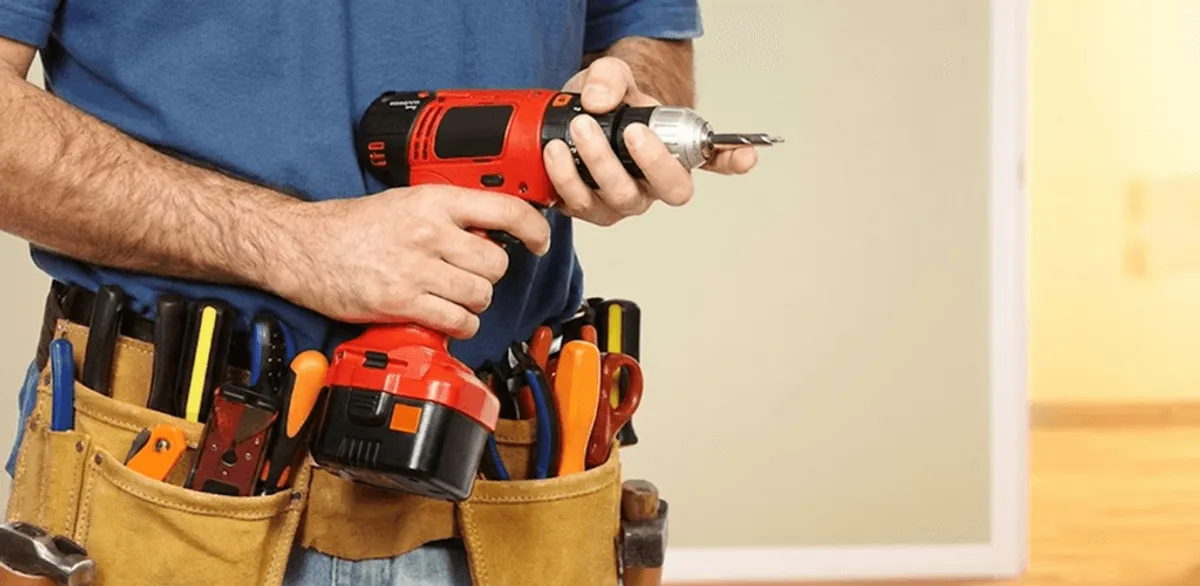 Handyman holding a power drill for home repairs and installations in Portland, OR