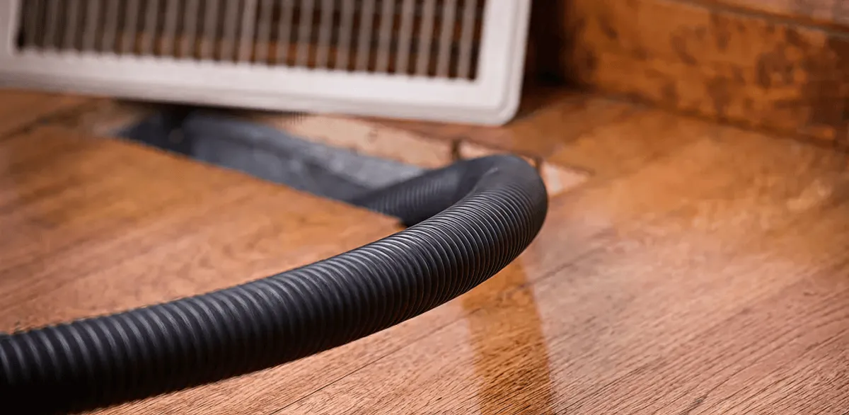 Air duct cleaning hose inserted into a floor vent for ductwork cleaning in Portland, OR